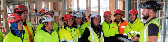 Group of construction workers onsite with manager