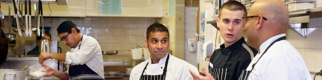 Head chef talking to staff in kitchen
