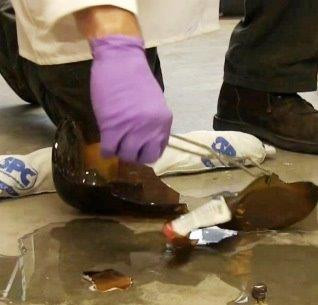 Worker removing broken glass off floor safely