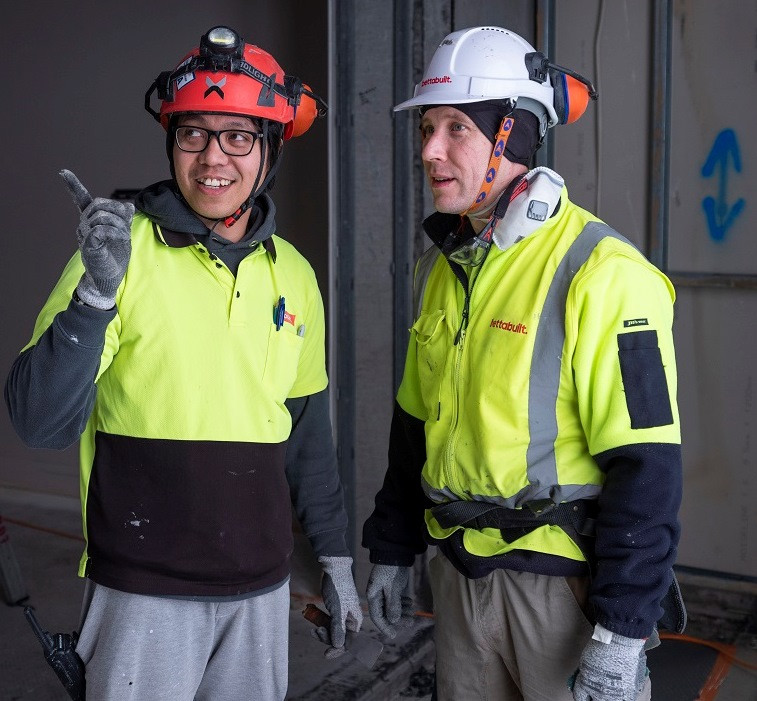 2 migrant construction workers talking