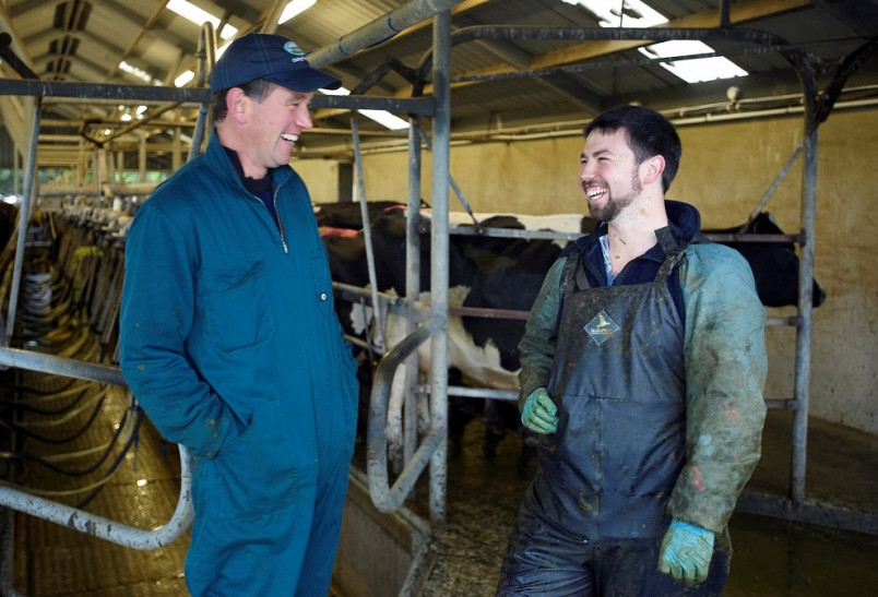 Worker talking to the boss in the cowshed