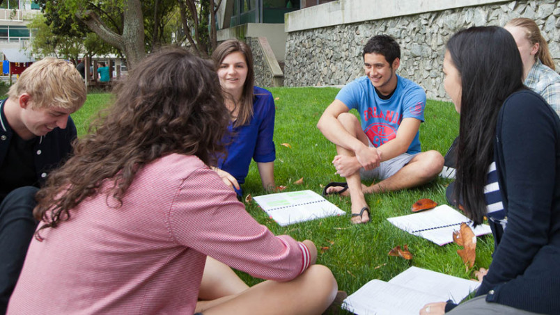 Students sitting on campus grounds talking